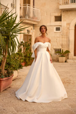 Vestido de noiva A-line em cetim branco com decote coração, ombros caídos, laço estruturado nas costas e espartilho.