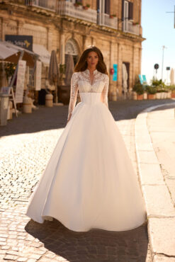 Ball gown wedding dress with high-neck lace bodice, beaded sheer long sleeves, and full satin skirt with cathedral train.