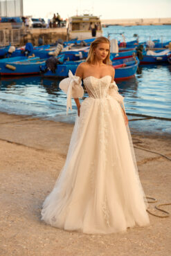 A-line wedding dress with sheer floral corset bodice, tulle skirt, and detachable puff sleeves with satin bows.