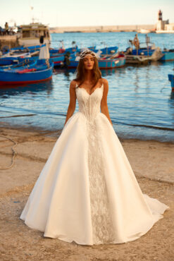 Ball gown wedding dress with sheer lace corset bodice, pearl button front, and full satin skirt with cathedral train.